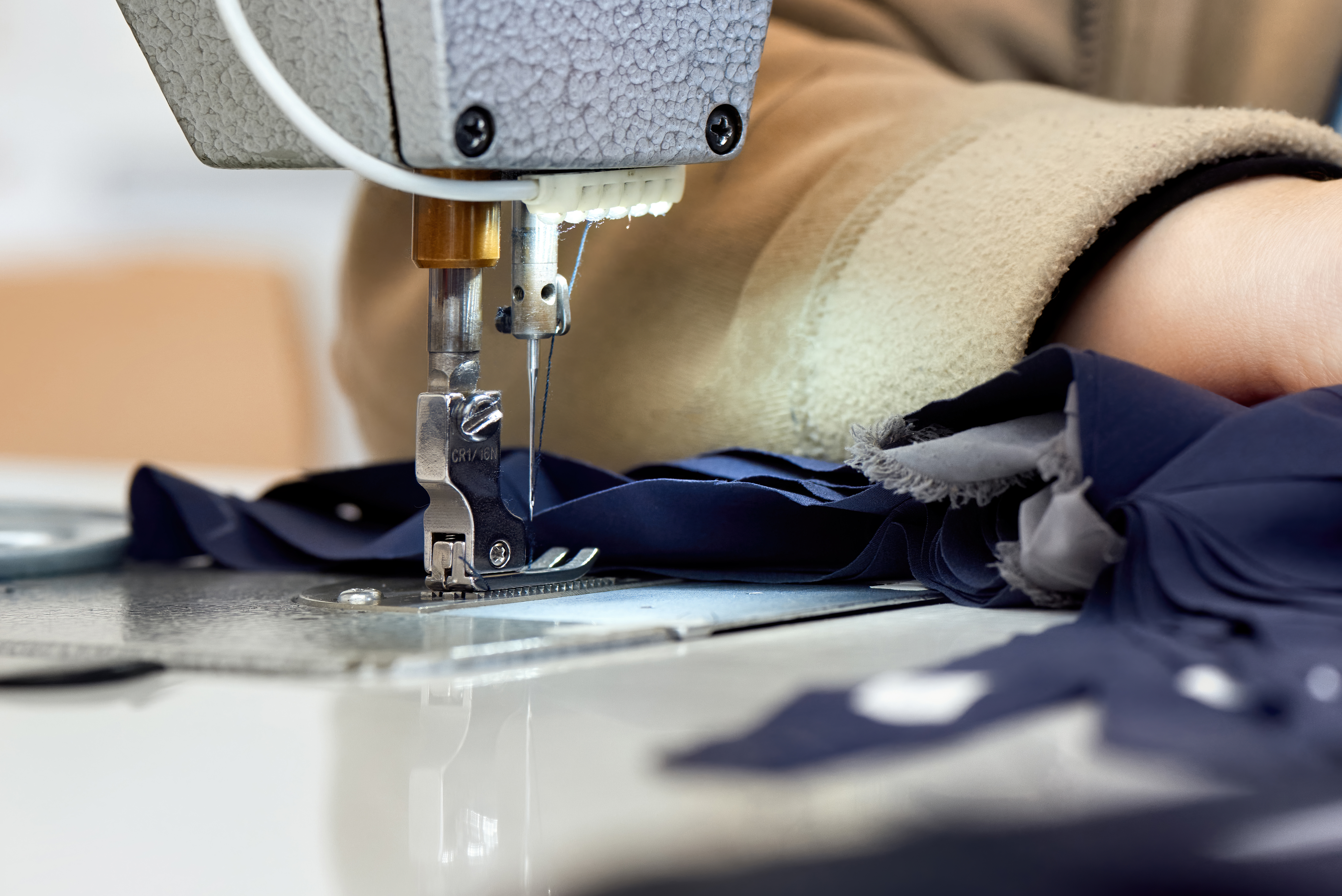 Confección de una prenda azul con máquina de coser